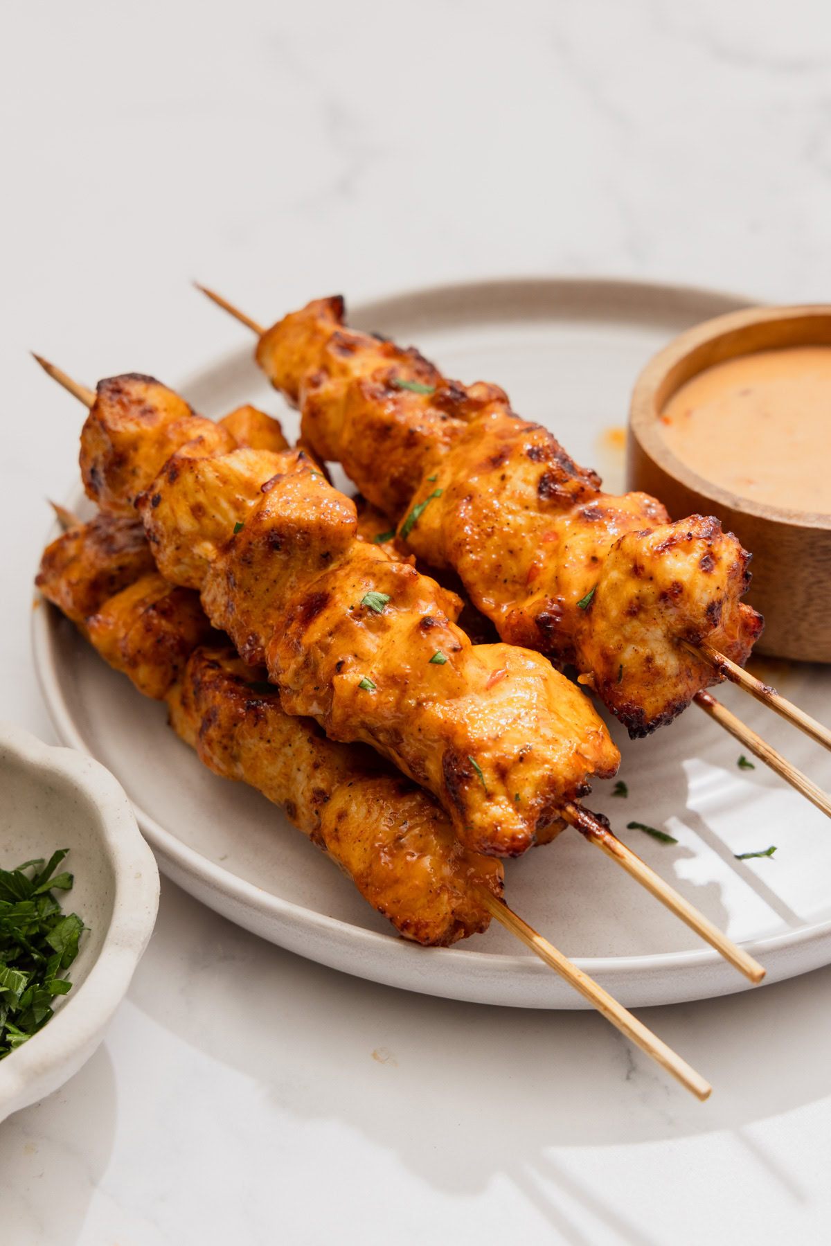 air fryer bang bang chicken skewers on a plate.