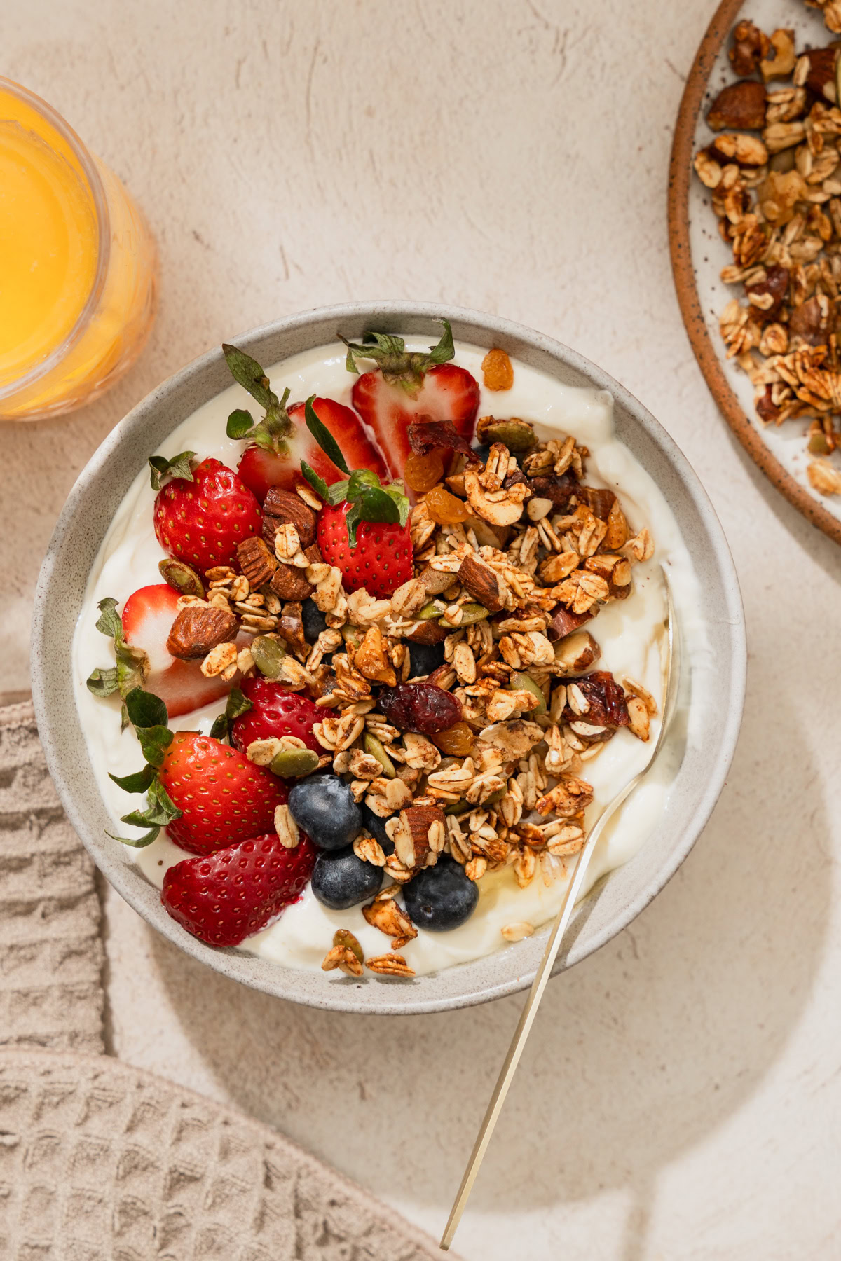 air fryer granola on a bowl with yogurt and fruits.