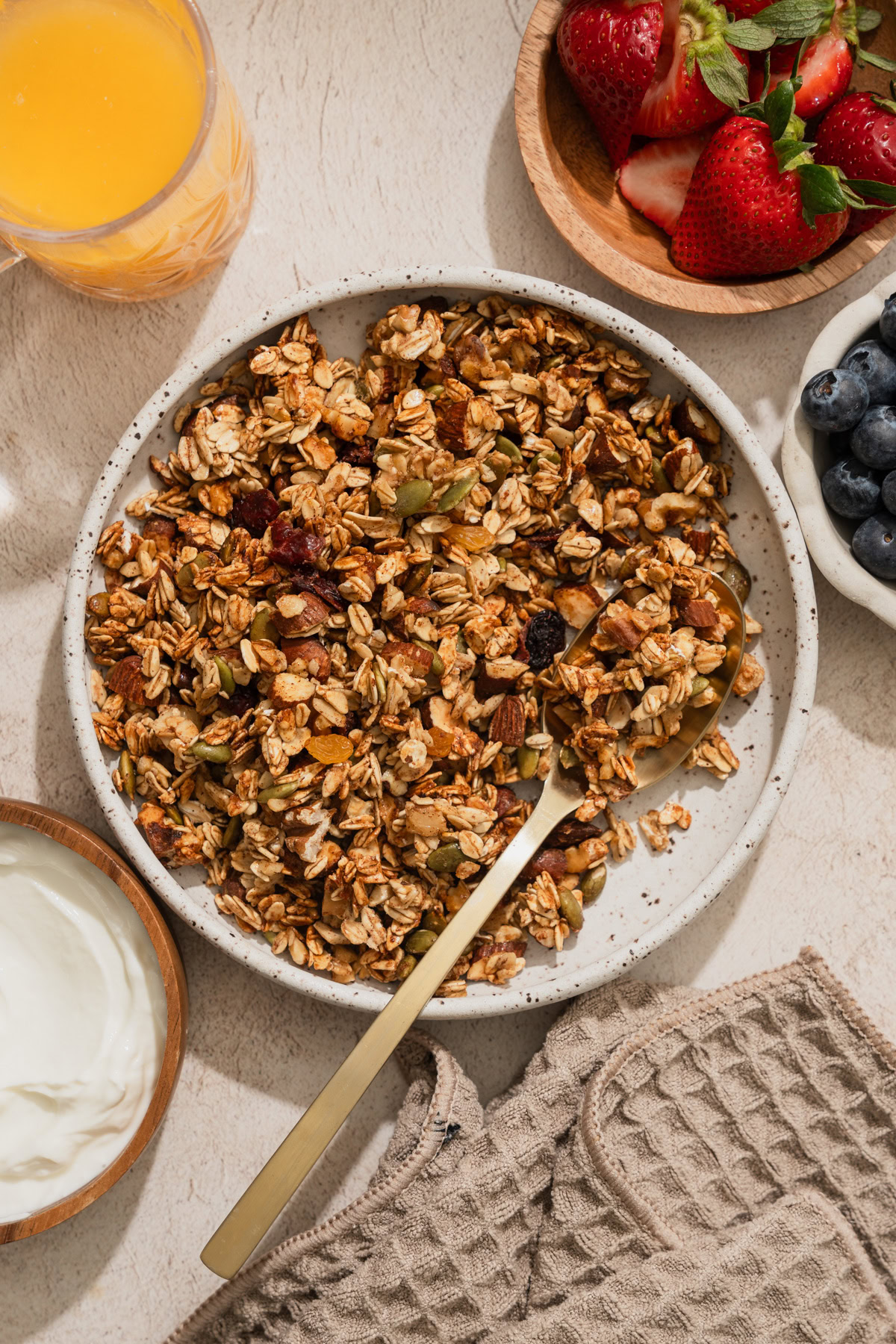 air fryer granola on a bowl with fruits on the side.