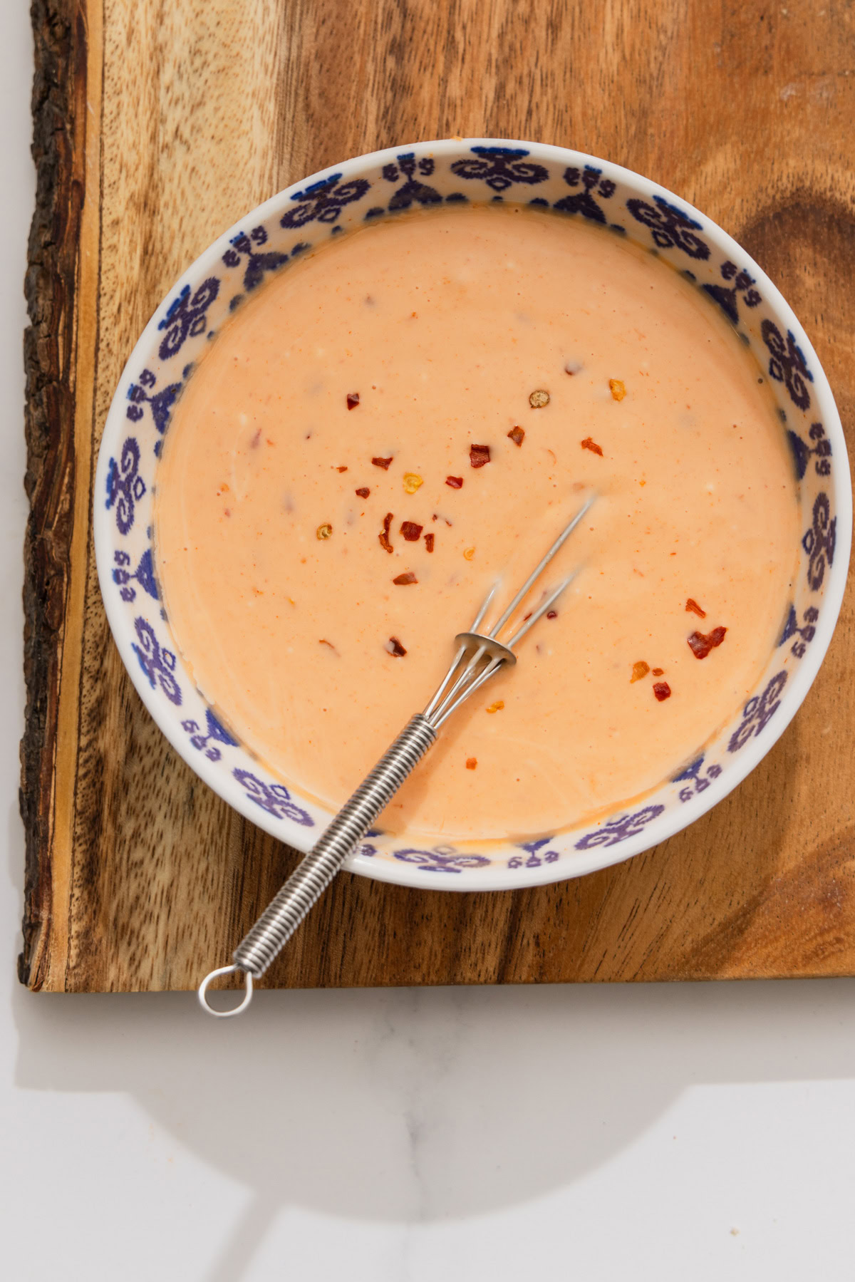 bang bang sauce in a bowl on a wooden board.