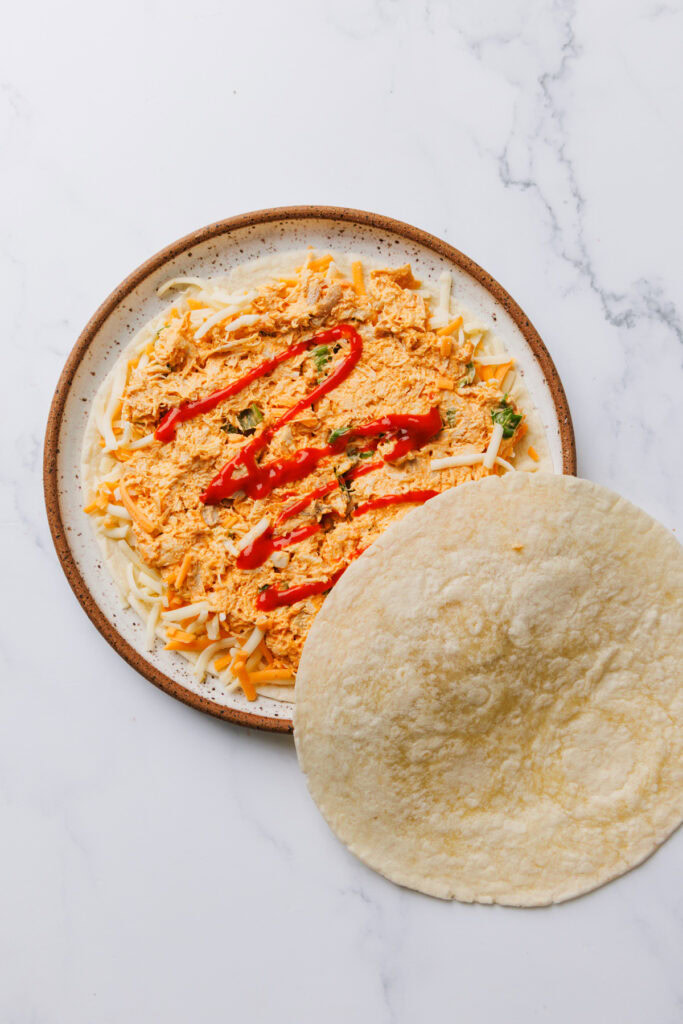 quesadilla being prepped on a plate.