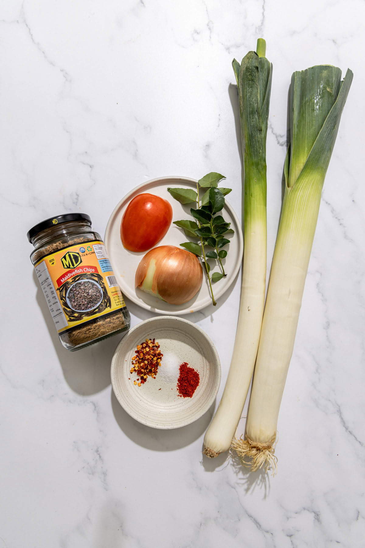 ingredients for Sri Lankan Leeks Curry on a marble background.