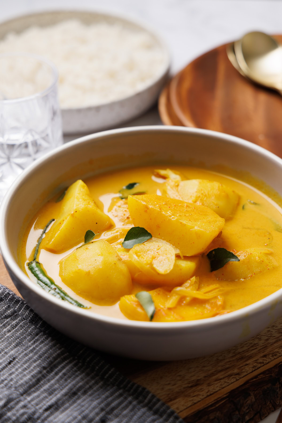 sri lankan potato curry on a bowl with rice on the side.