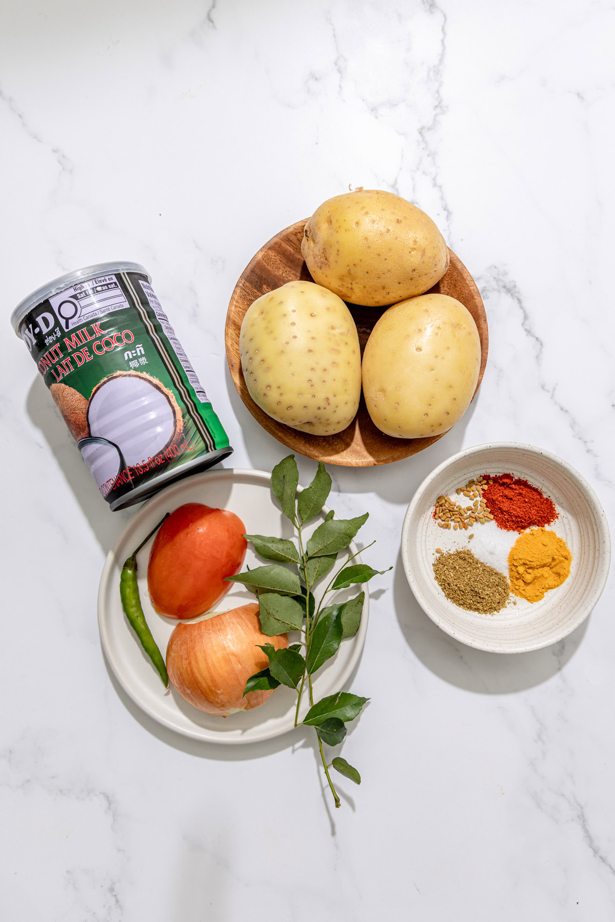 ingredients for sri lankan potato curry on a white background.