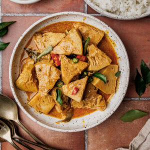 Sri Lankan jackfruit curry served in a bowl, garnished with sliced chilies and curry leaves.