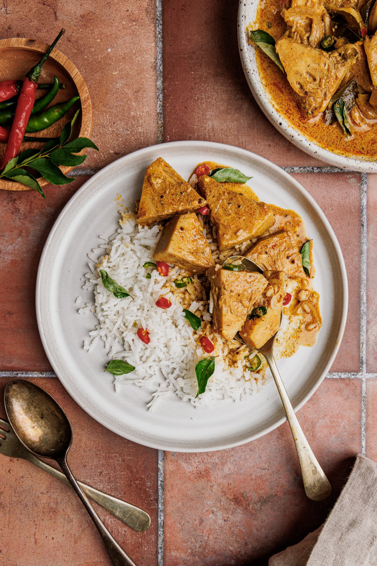 Polos curry served with rice, dal, and pol sambol on a plate